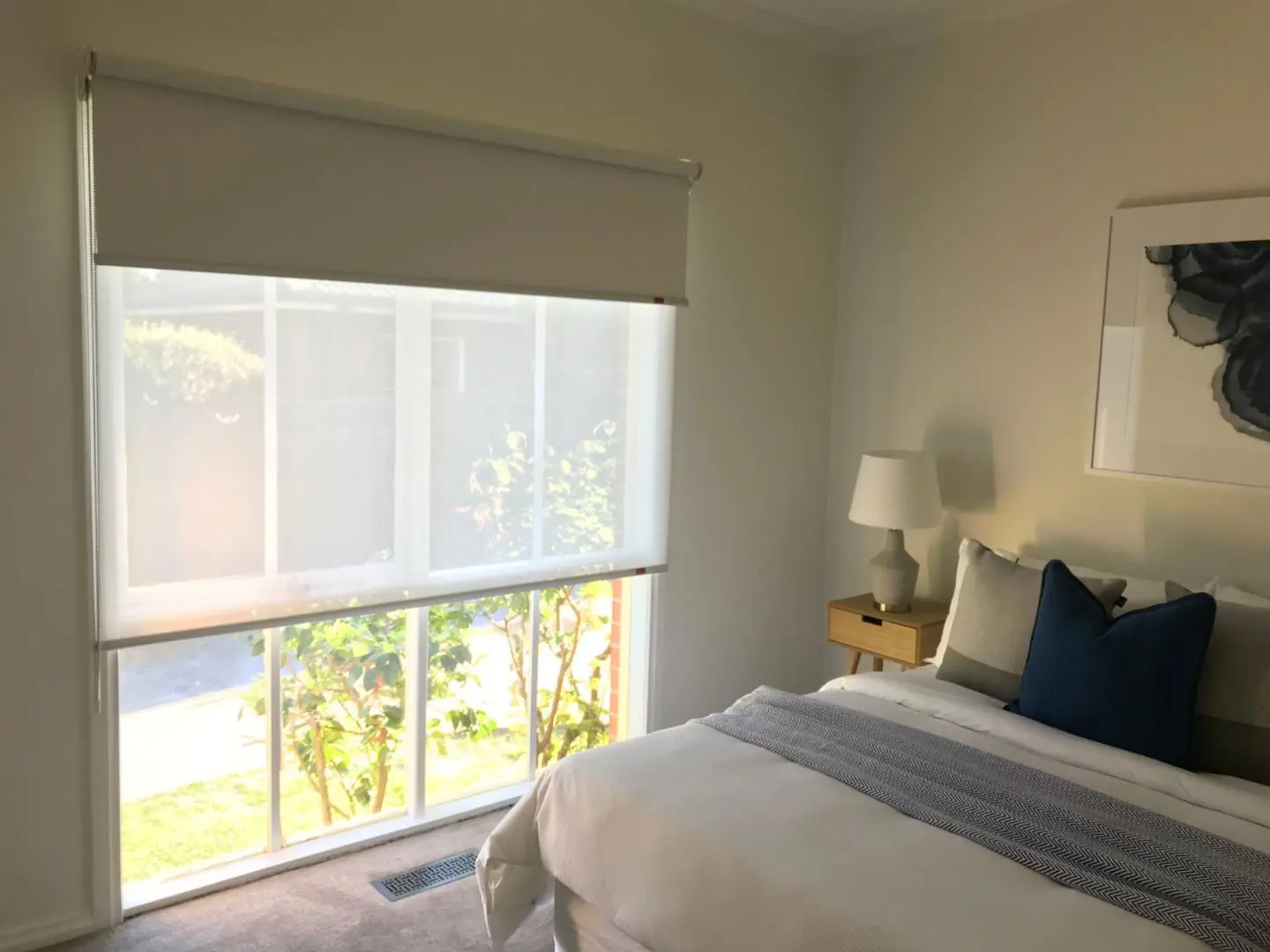 Modern bedroom featuring dual roller blinds for adjustable light and privacy.