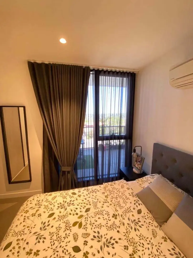 Cozy bedroom interior with stylish curtains, a comfortable bed, and modern décor.