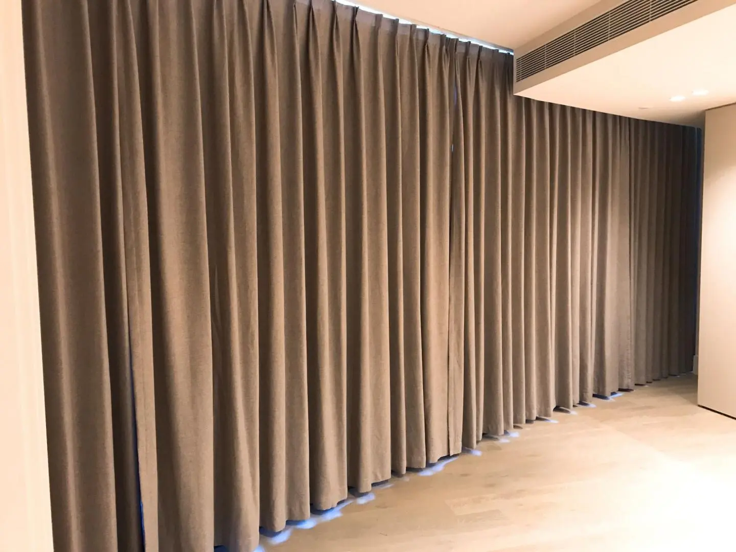 Beige curtains hang in a well-lit room, adding privacy and enhancing the interiors aesthetic.