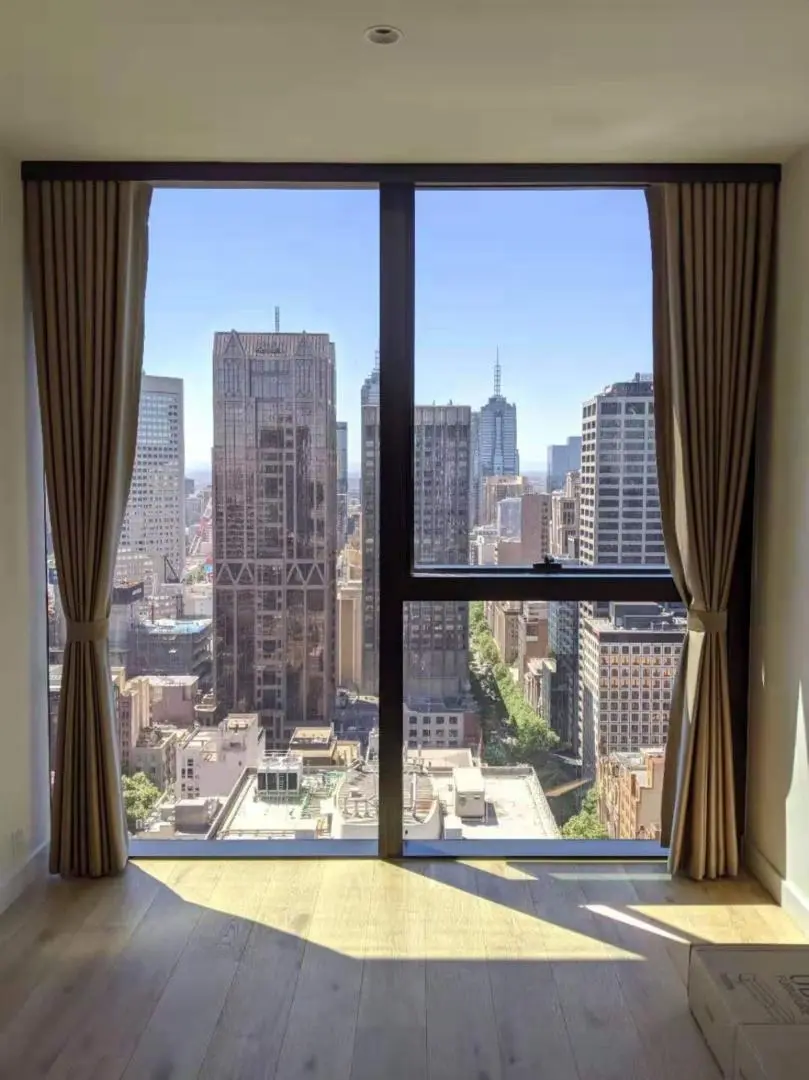 Urban apartment with city skyline views through a window.