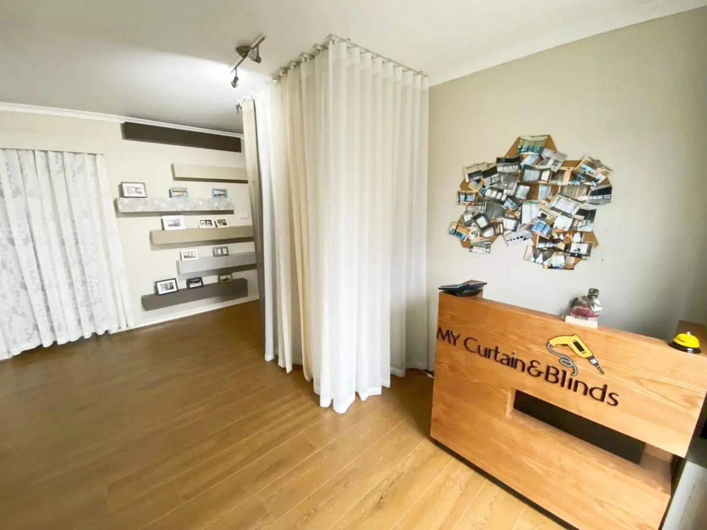 A well-lit curtain and blind store interior with a wooden desk and display shelves.