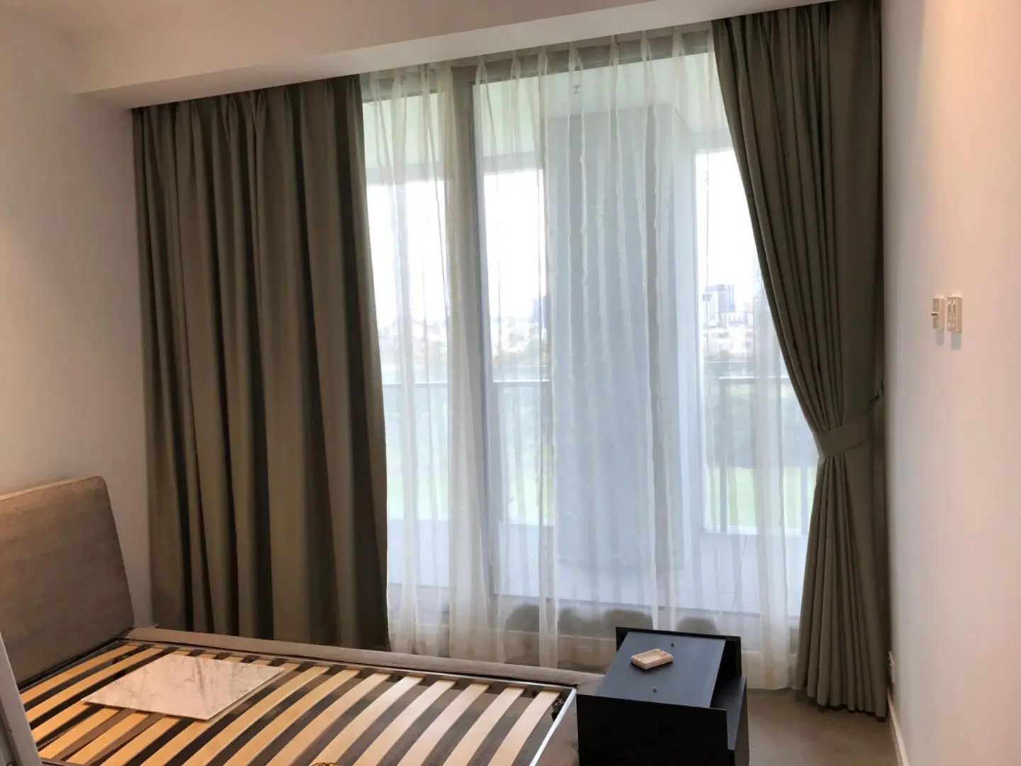 Bedroom features curtains for privacy and light control.