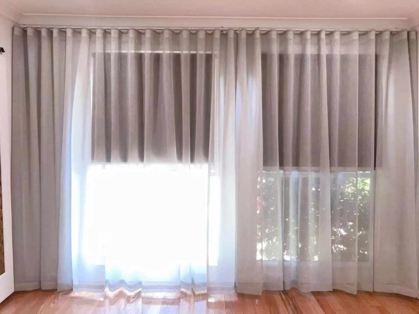 Sheer curtains and drapes filter light through a window, enhancing the living rooms design.