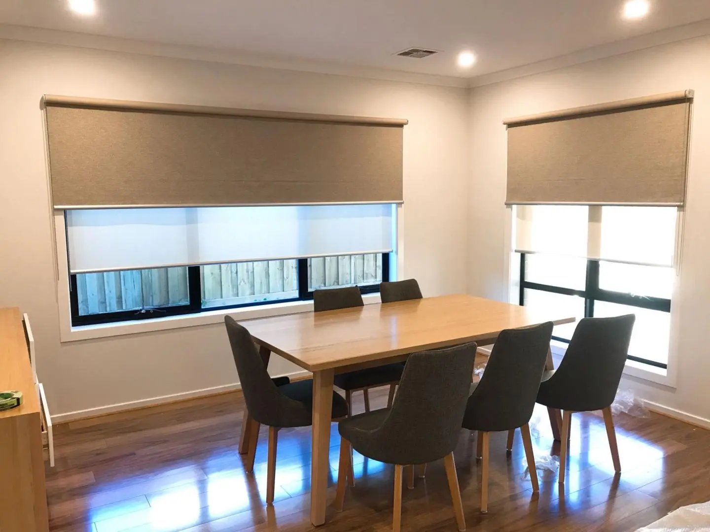 Dining room with dual roller blinds for enhanced light and privacy.