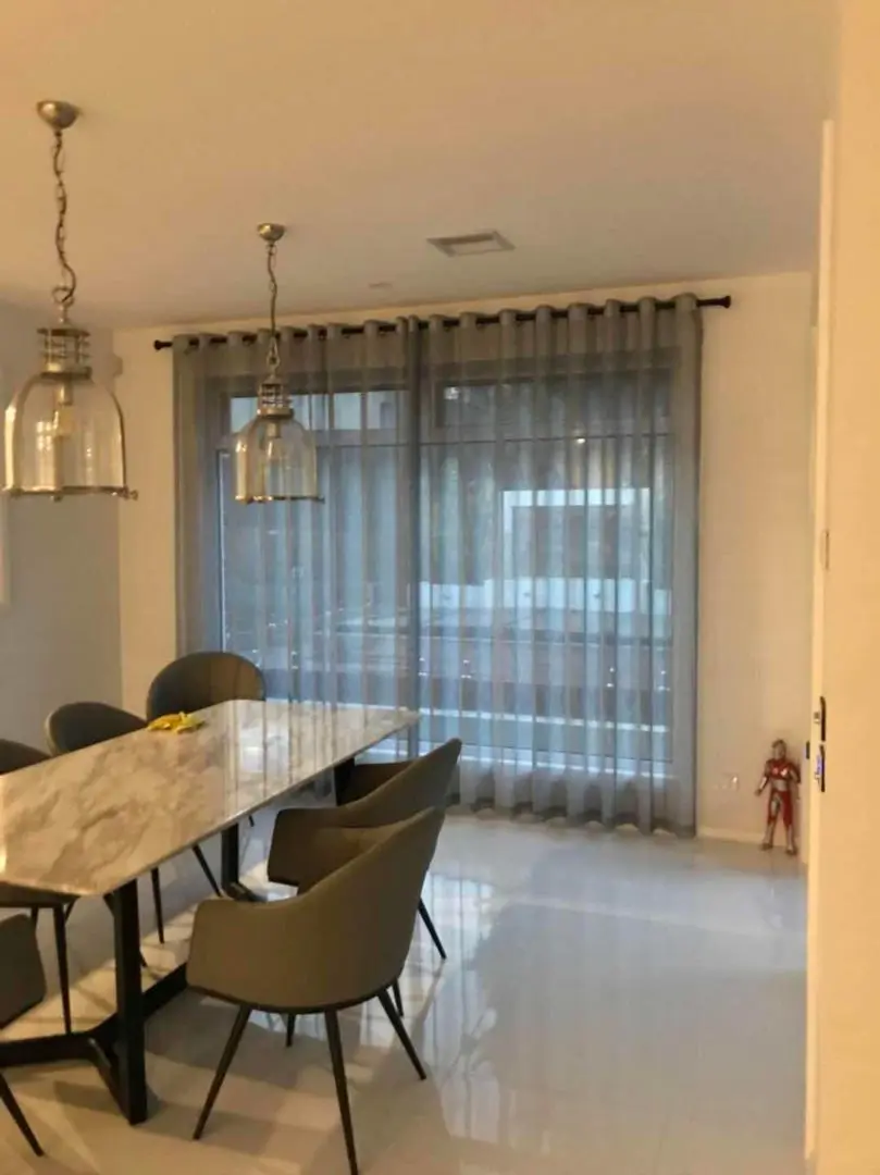 Modern dining room design with sheer curtains and stylish furniture.
