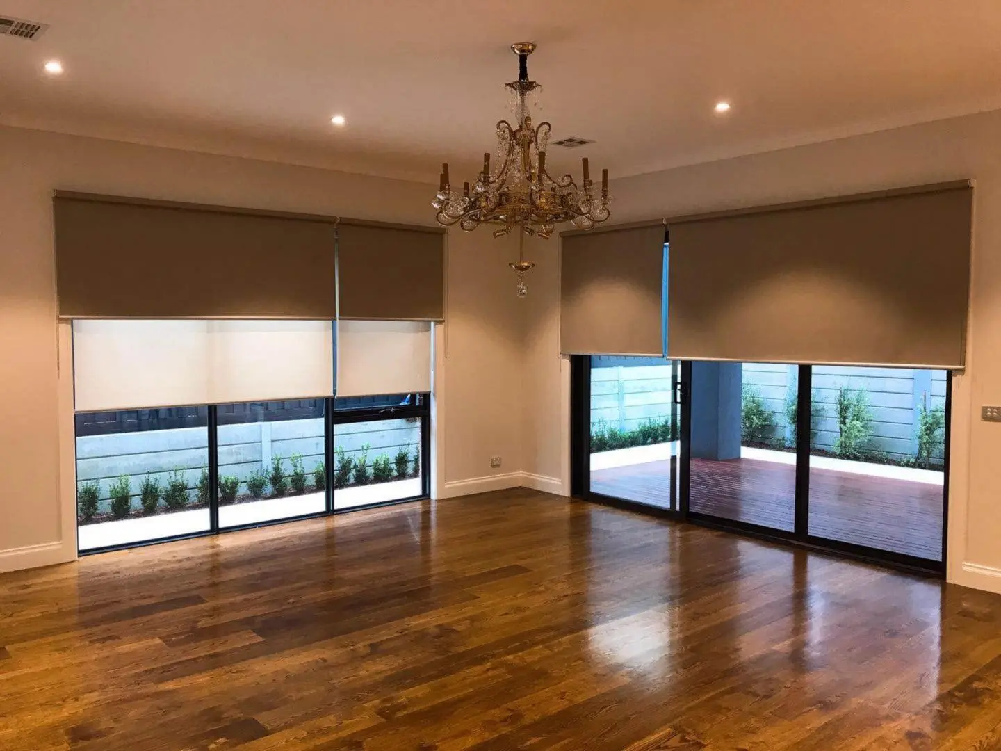 Elegant living room featuring blinds, a chandelier, and hardwood floors.