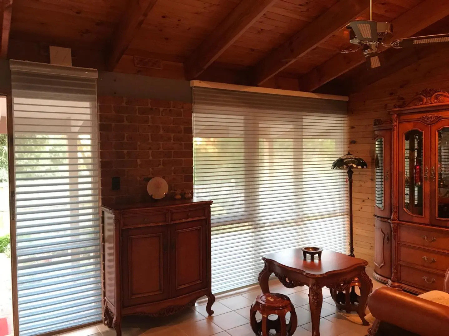 Elegant living room interior with stylish blinds and traditional furniture.