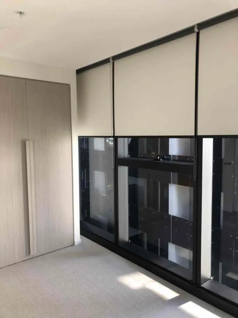 Stylish modern bedroom featuring a light wood wardrobe and a sleek glass display cabinet.