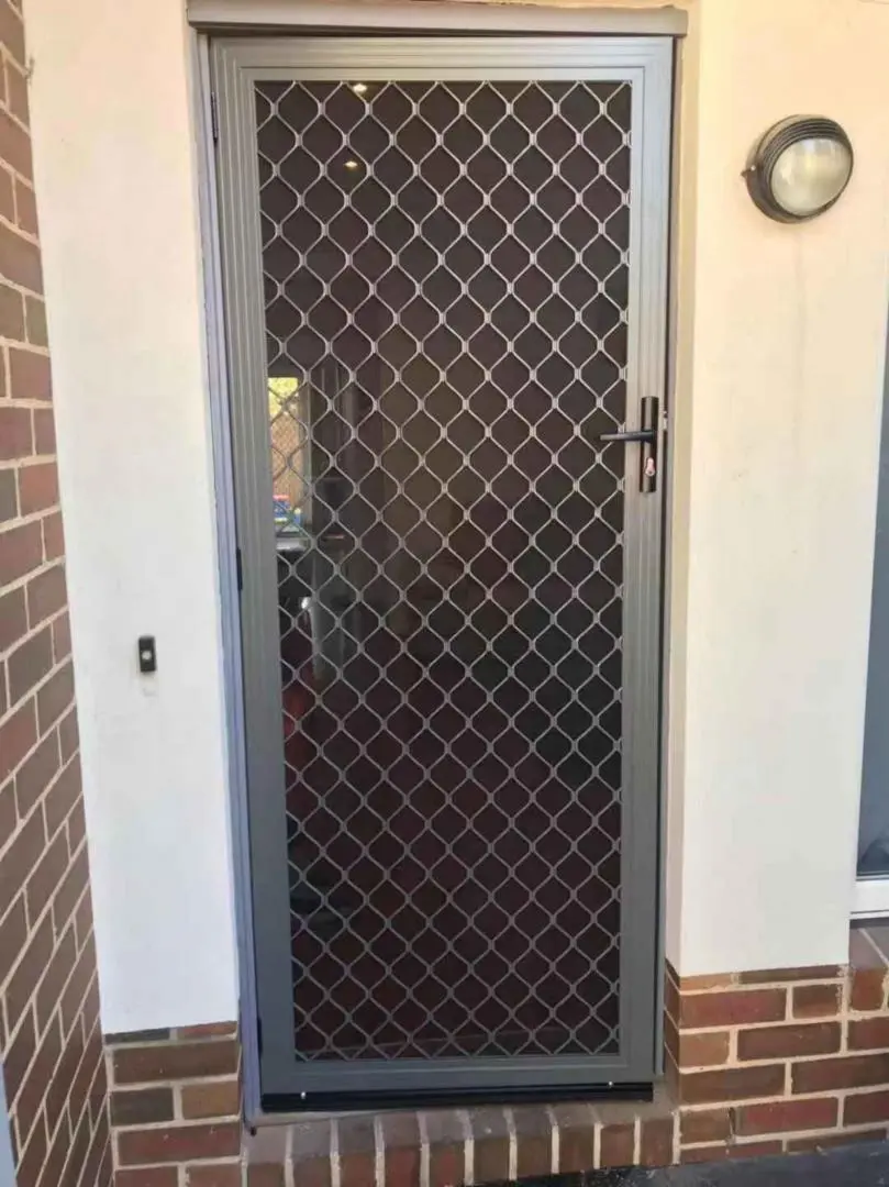 Diamond pattern security door on a house exterior.
