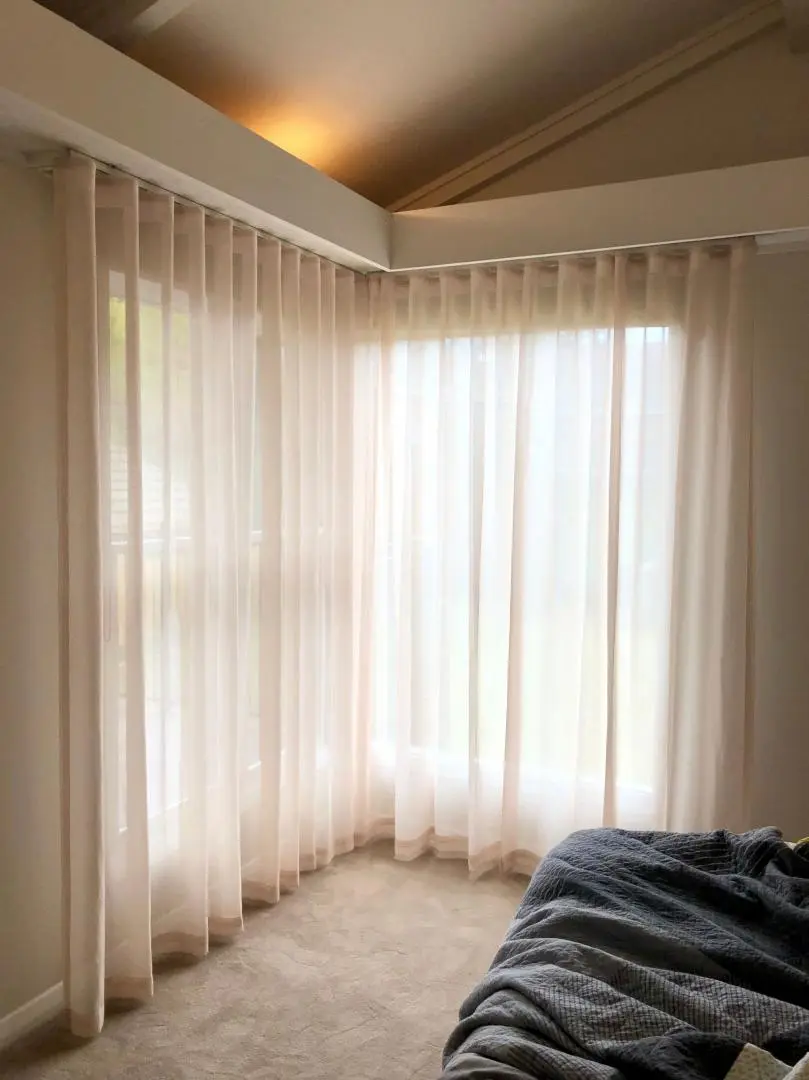 Sheer curtains in a bedroom offer privacy and diffused natural light.