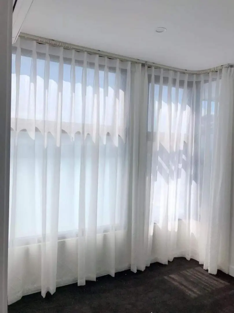 Elegant sheer white curtains softly filter light in a modern room.