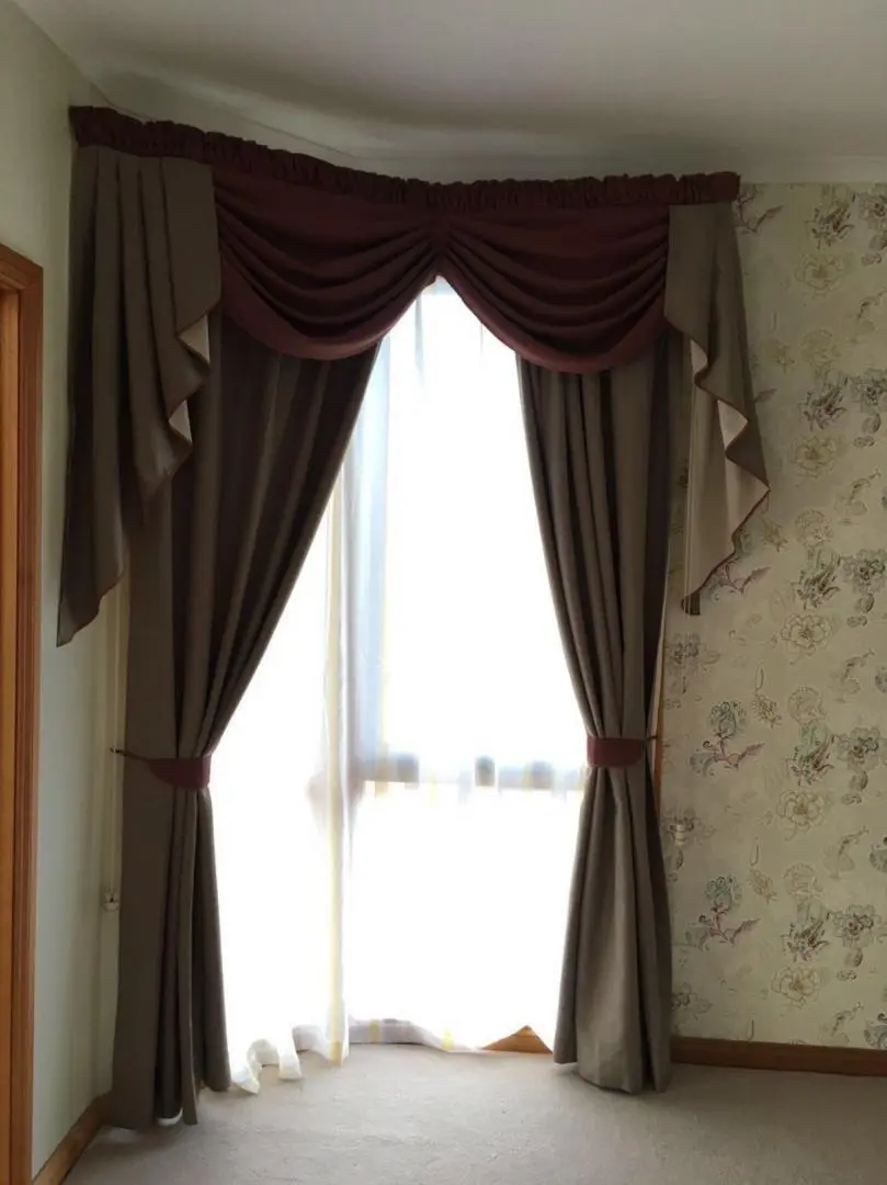 Brown drapes frame a bright window, adding elegance to the room.